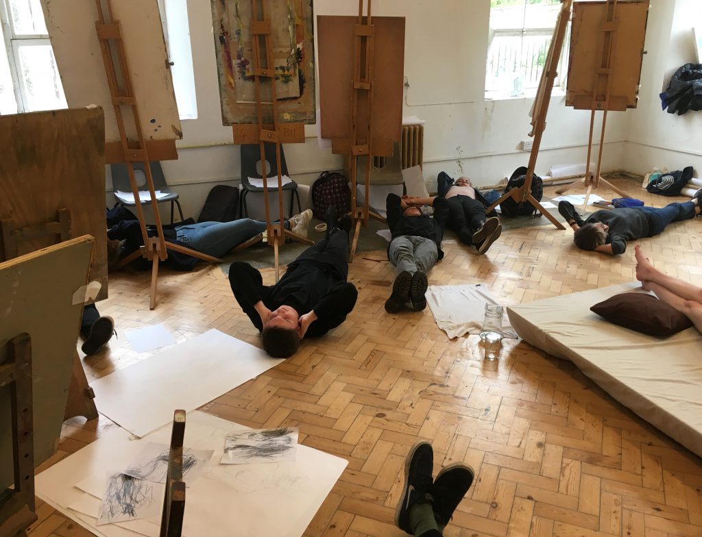 Students lying on the floor during a life drawing study