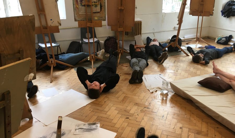 Students lying on the floor during a life drawing study