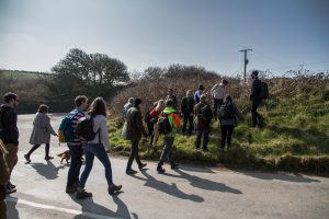 People crossing a lane and walking into a field
