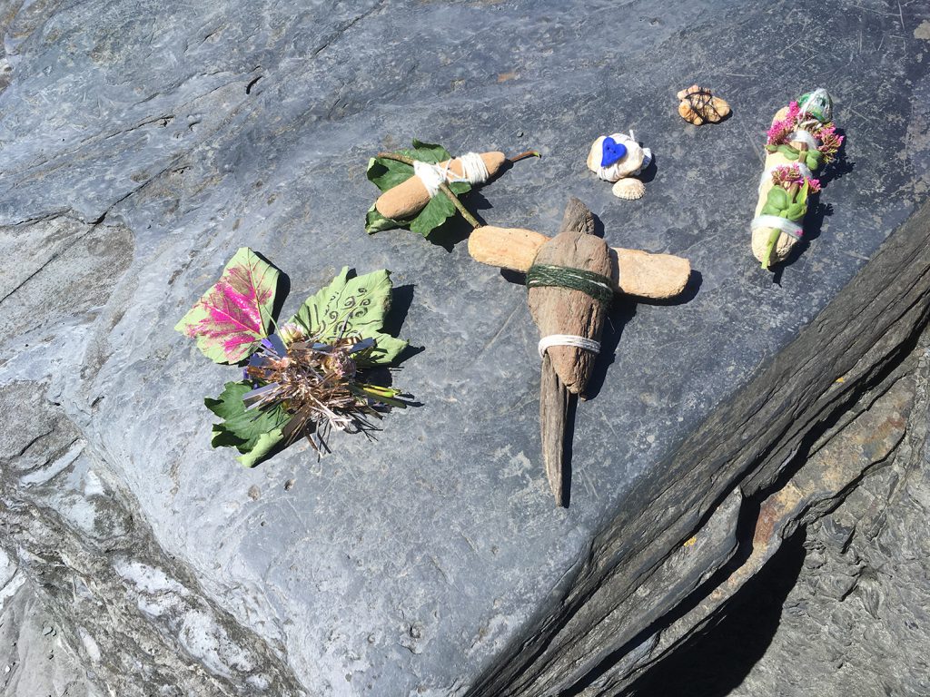 small objects bound together with twine, on a rock