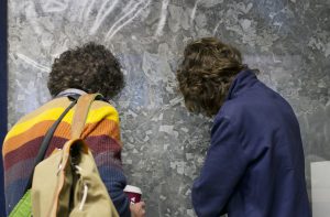 Two men looking closely at a large photograph