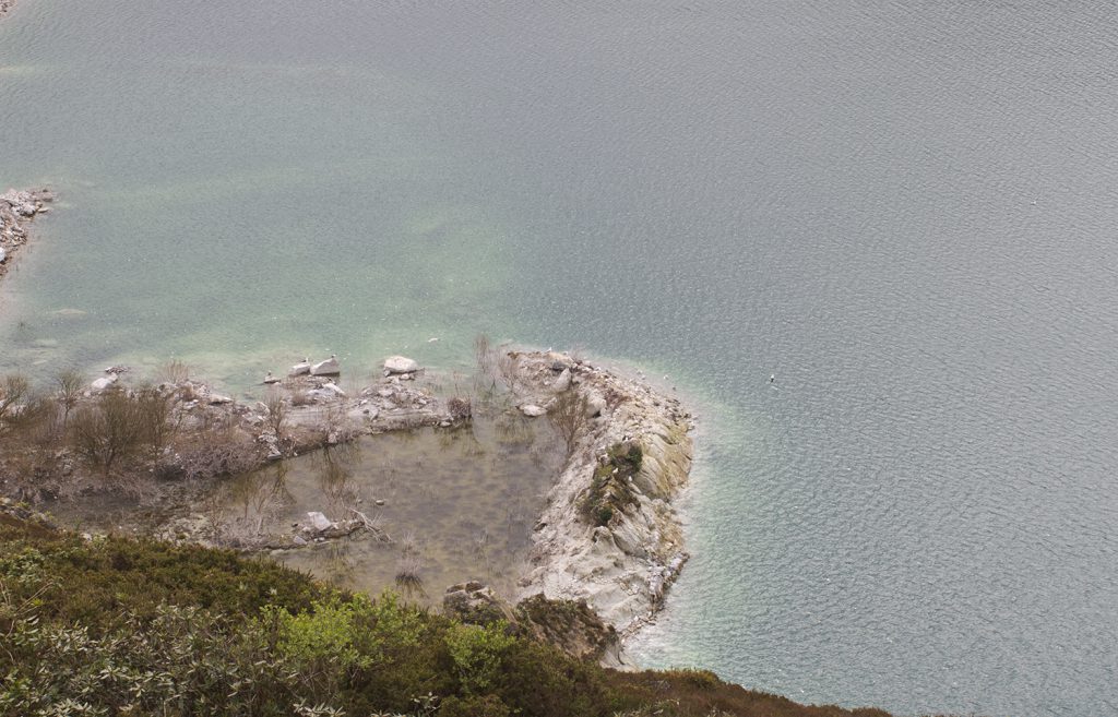 A rock formation on the edge of a body of water