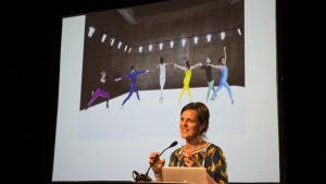 A woman speaking at a lecturn